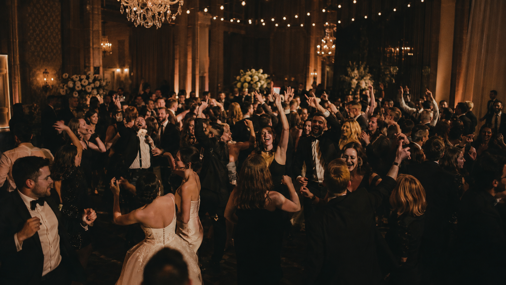 Aureo — wedding guests dancing under chandeliers and warm lights